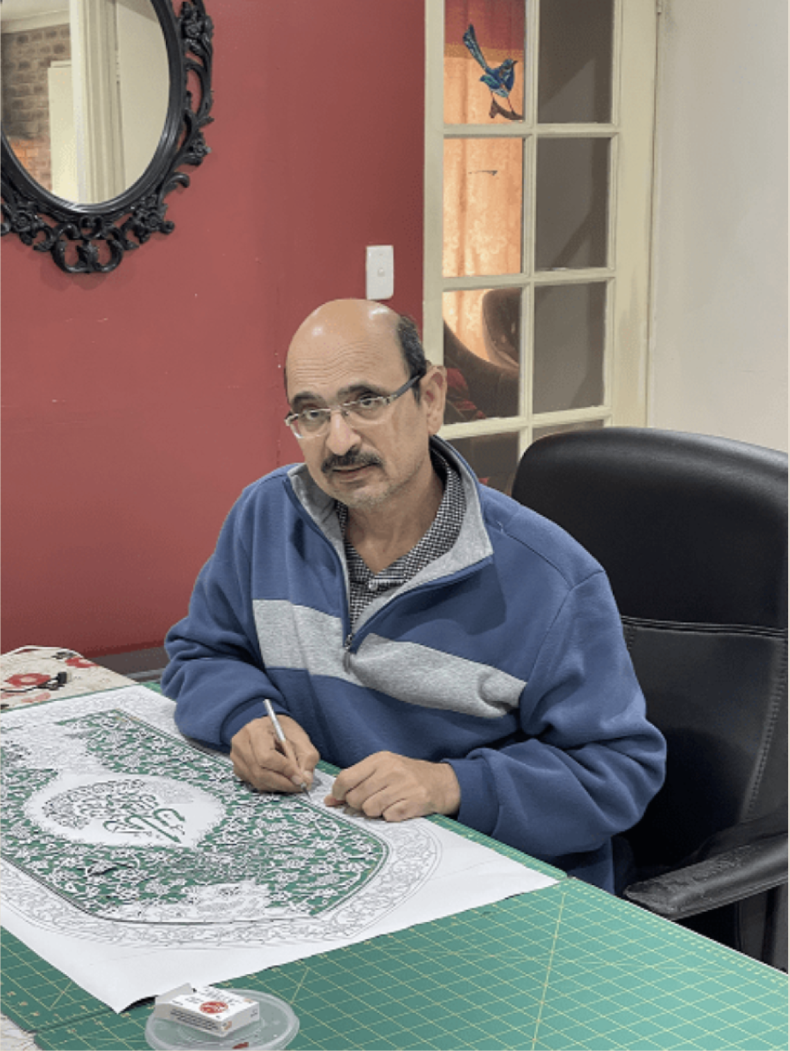 Tusif Ahmad working on an Islamic paper-cutting artwork