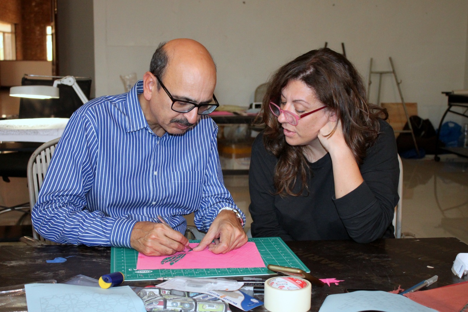 Participants learning paper cutting techniques during a workshop