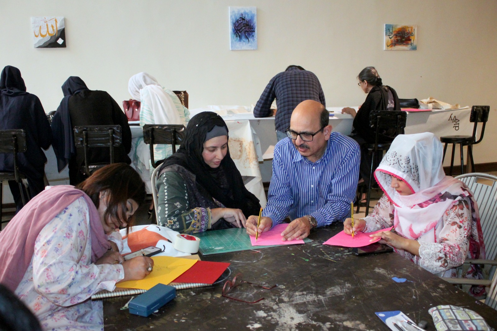 Tusif Ahmad workshop participants viewing Islamic papercutting artwork